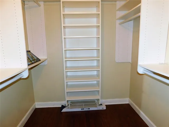 a view of walk in closet with empty racks