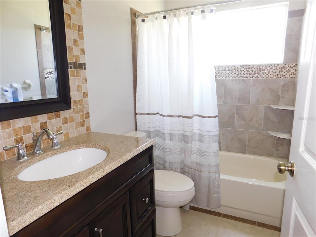 9353 Vía Segovia New Port Richey, FL 34655 - Photo 20 of 25 a bathroom with a granite countertop sink toilet and shower