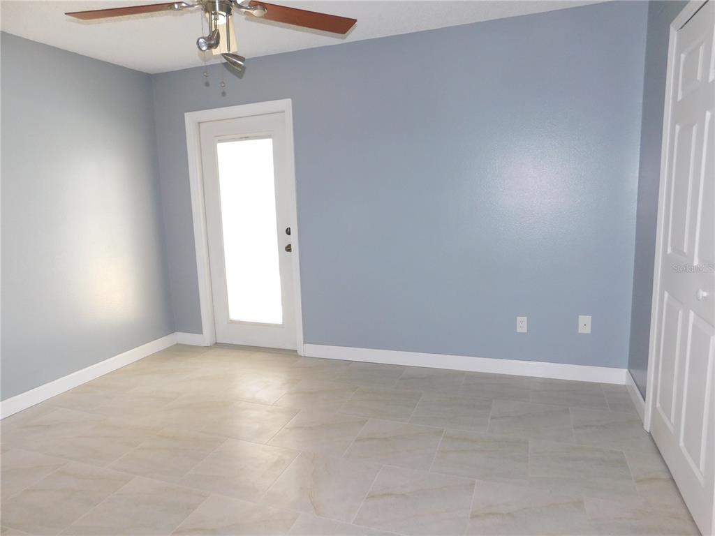 9353 Vía Segovia New Port Richey, FL 34655 - Photo 21 of 25 an empty room with a window and a chandelier fan