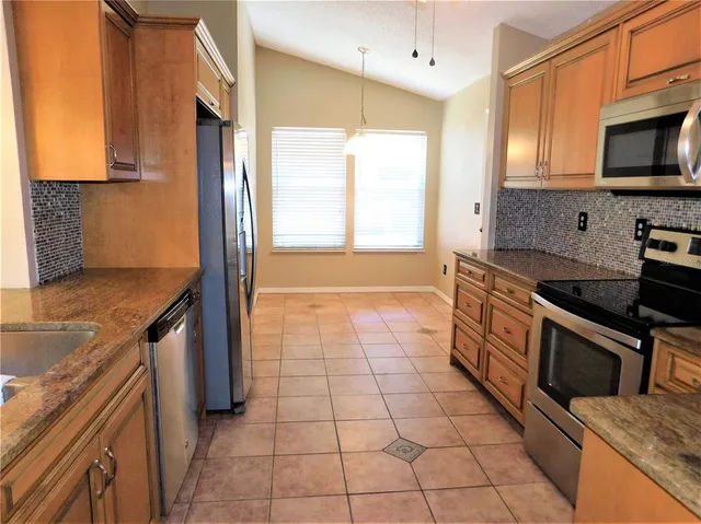 a kitchen with stainless steel appliances granite countertop a stove a sink and a microwave