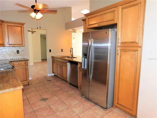 a kitchen with granite countertop a refrigerator and a sink