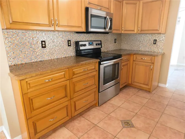 a kitchen with granite countertop white cabinets stainless steel appliances and sink