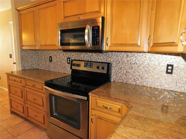 a kitchen with granite countertop cabinets stainless steel appliances and wooden floor