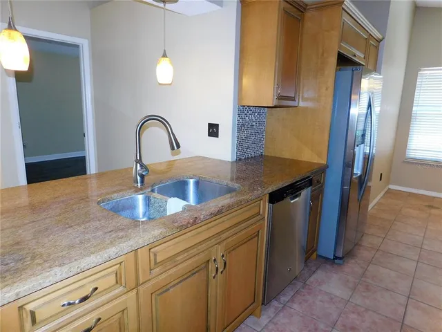 a kitchen with stainless steel appliances granite countertop a sink a stove and a refrigerator