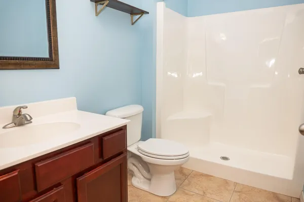 an empty room with wooden floor closet and windows
