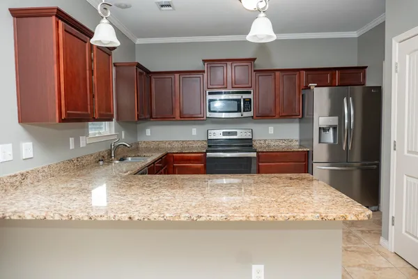 a kitchen with stainless steel appliances granite countertop a sink refrigerator and microwave