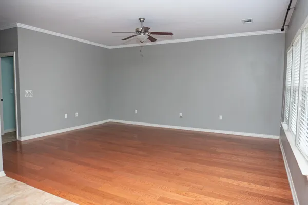 a view of an empty room with a window and a ceiling fan