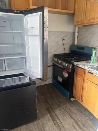 a kitchen with granite countertop a stove and a refrigerator