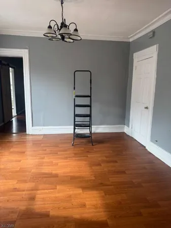 a view of a room with wooden floor and white walls