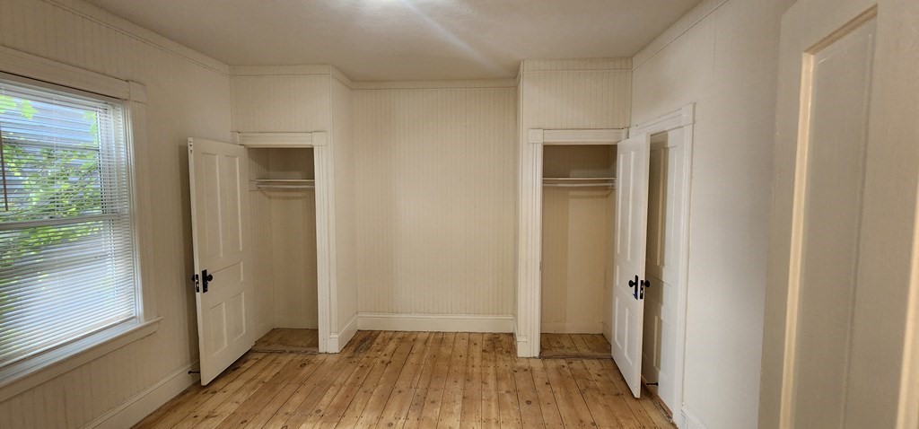 a view of a hallway with wooden floor and a window