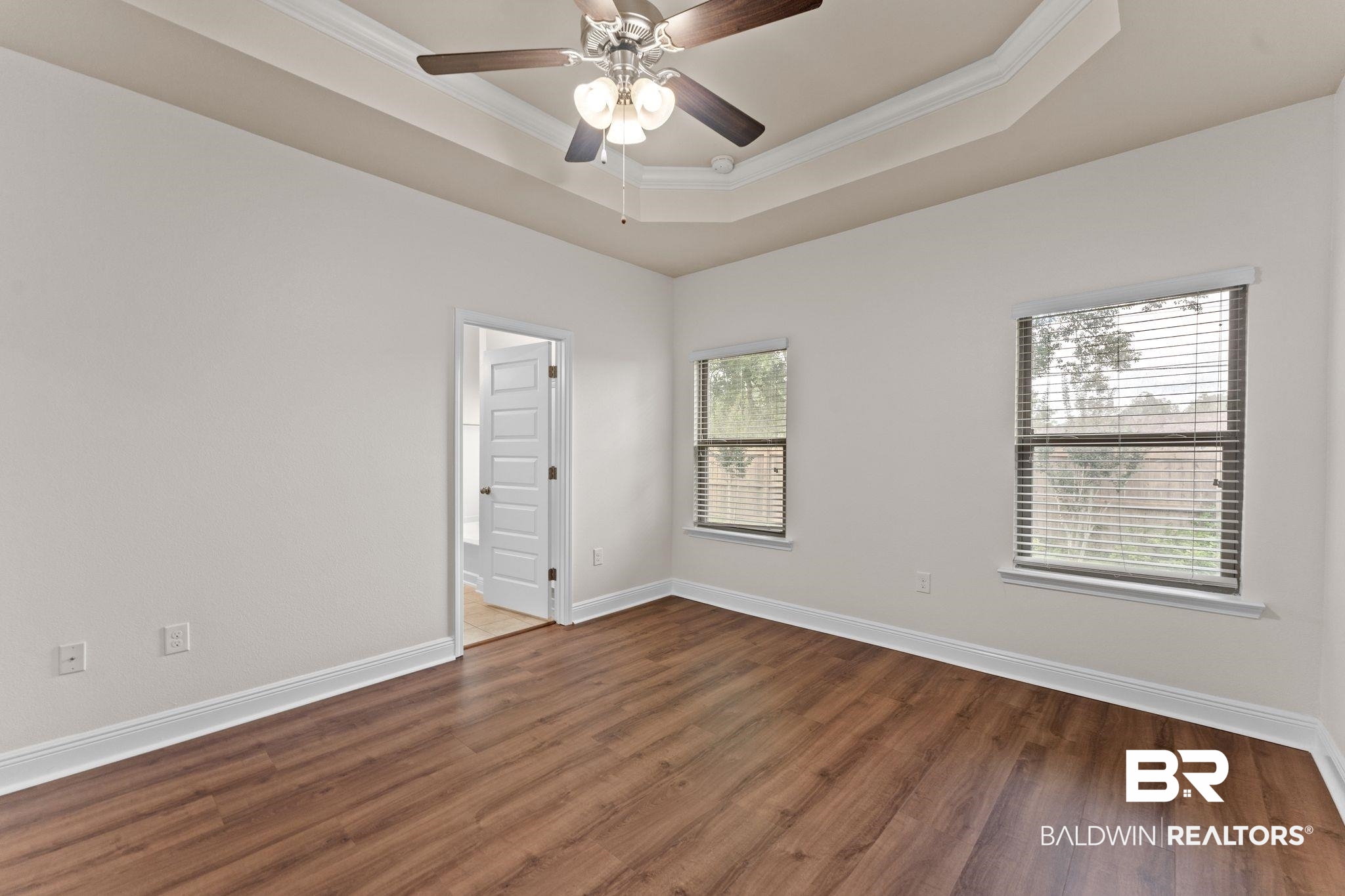 1464 Surrey Loop Foley, AL 36535 - Photo 16 of 24 Unfurnished room with crown molding, wood finished floors, a tray ceiling, and ceiling fan
