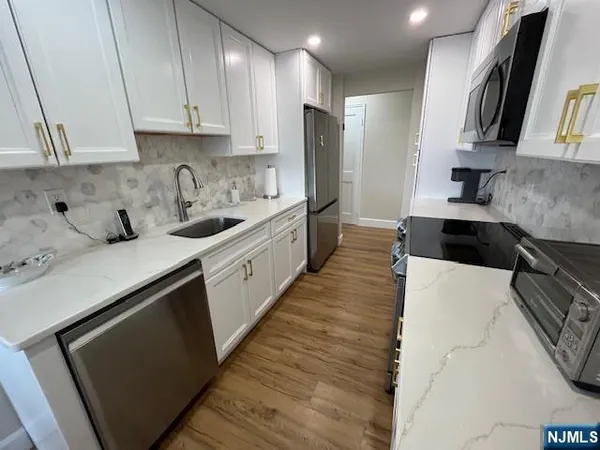 a kitchen with stainless steel appliances a sink stove and refrigerator