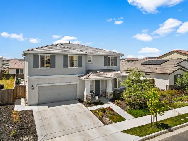 a front view of a house with plants