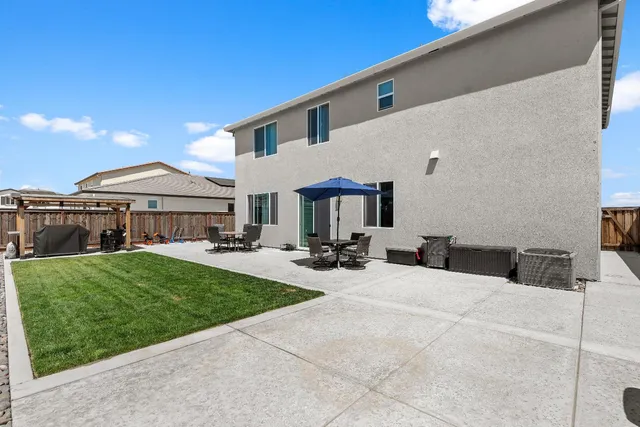 a view of a patio with a table and chairs under an umbrella