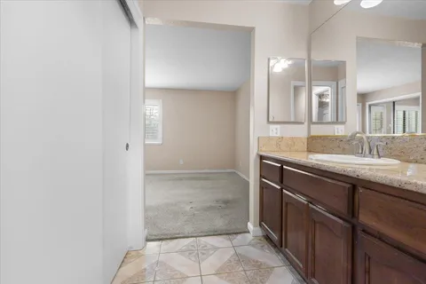 a bathroom with a granite countertop sink and a mirror