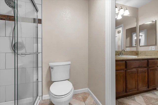 a bathroom with a granite countertop toilet sink and a mirror