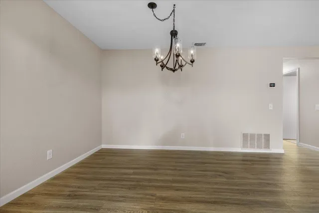 a view of a room with wooden floor and white walls