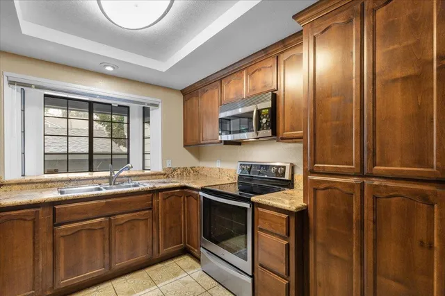 a kitchen with stainless steel appliances a stove a sink and a microwave
