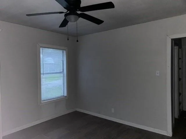 an empty room with a window and a fan