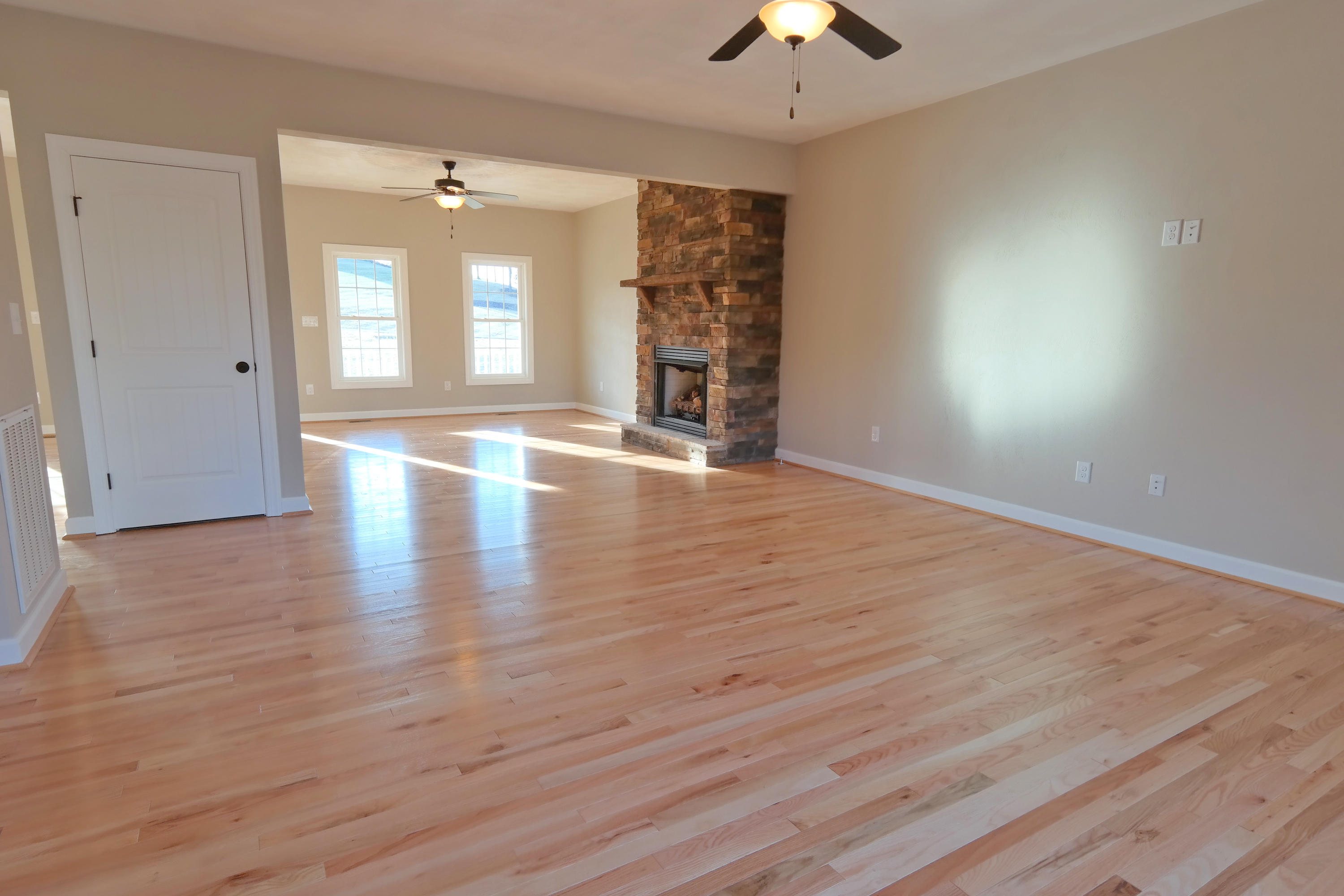 594 Thornblade Way Blue Ridge, VA 24064 - Photo 6 of 21 an empty room with wooden floor chandelier and windows