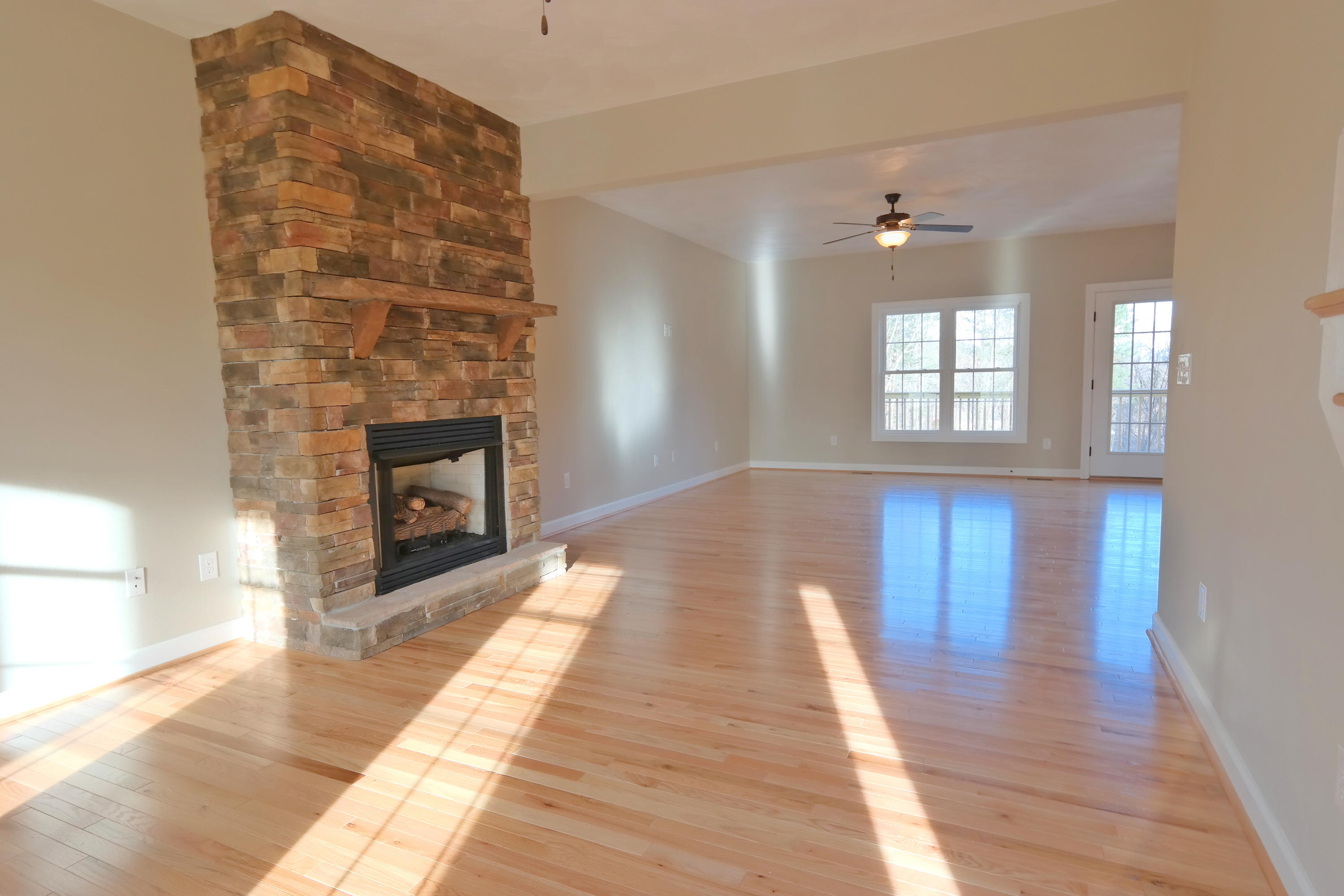 594 Thornblade Way Blue Ridge, VA 24064 - Photo 8 of 21 a view of an empty room with wooden floor and a fireplace