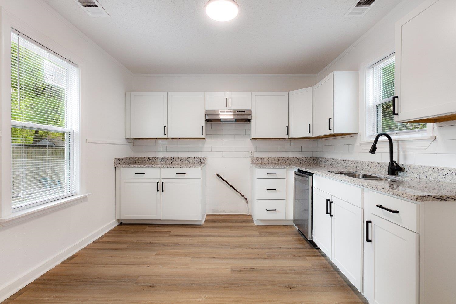 41 North Bingham Street Memphis, TN 38112 - Photo 3 of 9 a kitchen with granite countertop white cabinets and white appliances with wooden floor