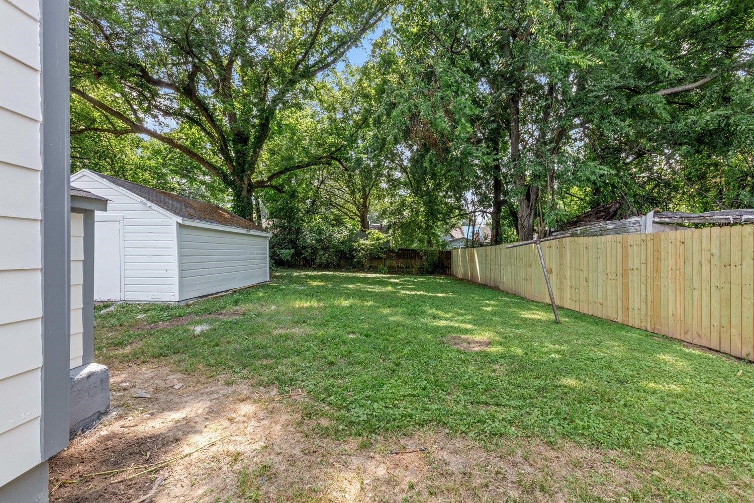 41 North Bingham Street Memphis, TN 38112 - Photo 9 of 9 a view of a backyard with a large tree and wooden fence