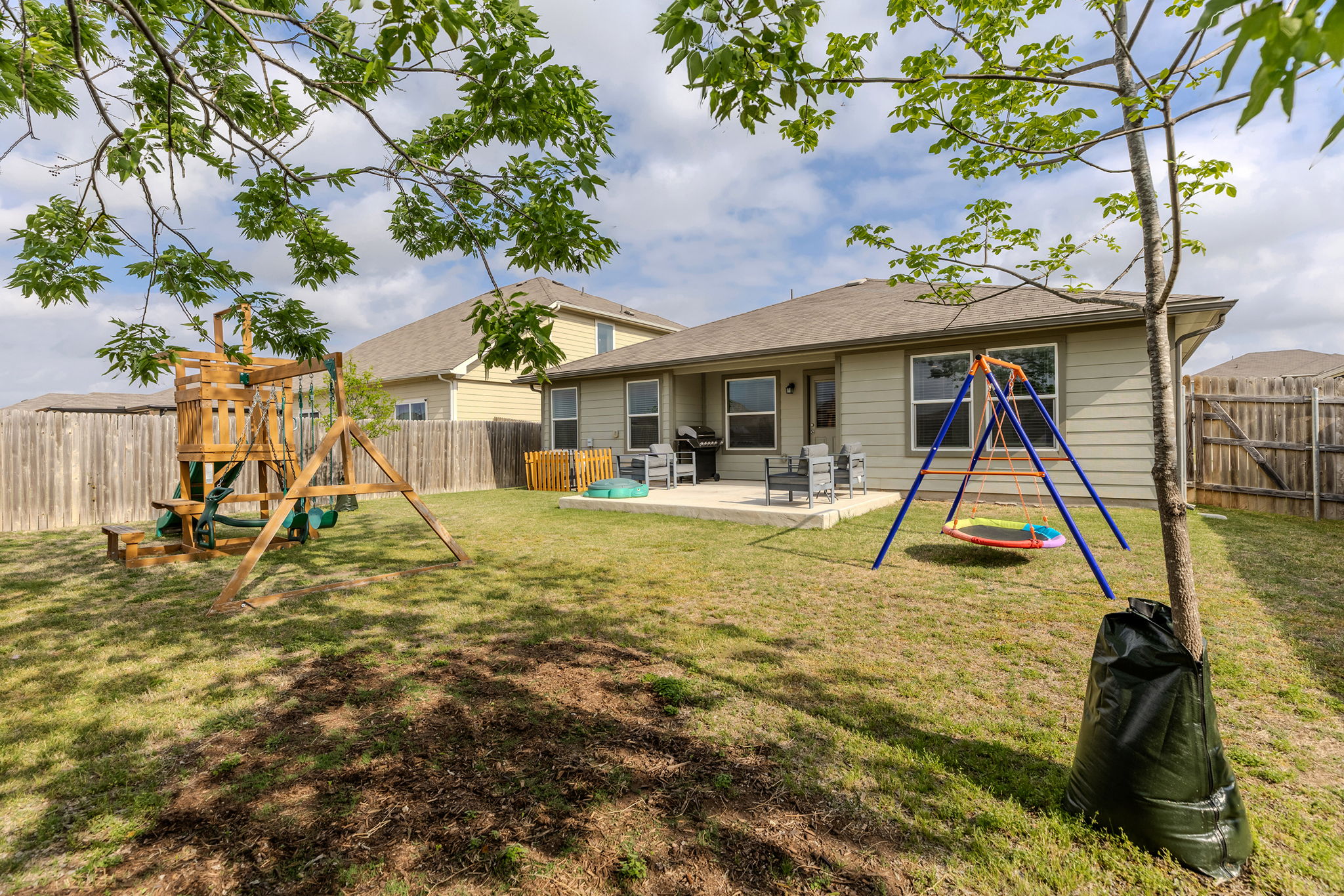 404 Cassandra Drive Hutto, TX 78634 - Photo 36 of 40 Back of property with a playground, a fenced backyard, and a patio area