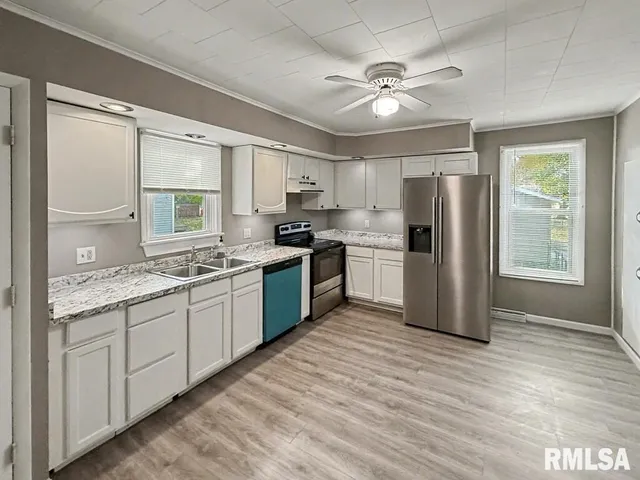 a kitchen with stainless steel appliances granite countertop a refrigerator a stove a sink and dishwasher with wooden floor