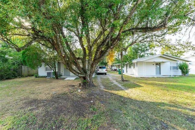 a view of a yard with a house and a large tree