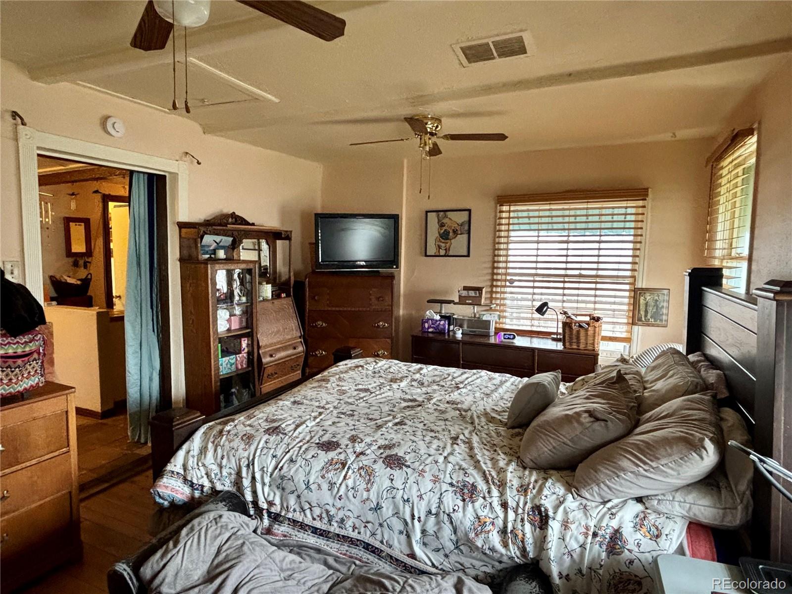 2568 Eaton Street Edgewater, CO 80214 - Photo 2 of 11 a bedroom with a bed a flat screen tv and a chandelier