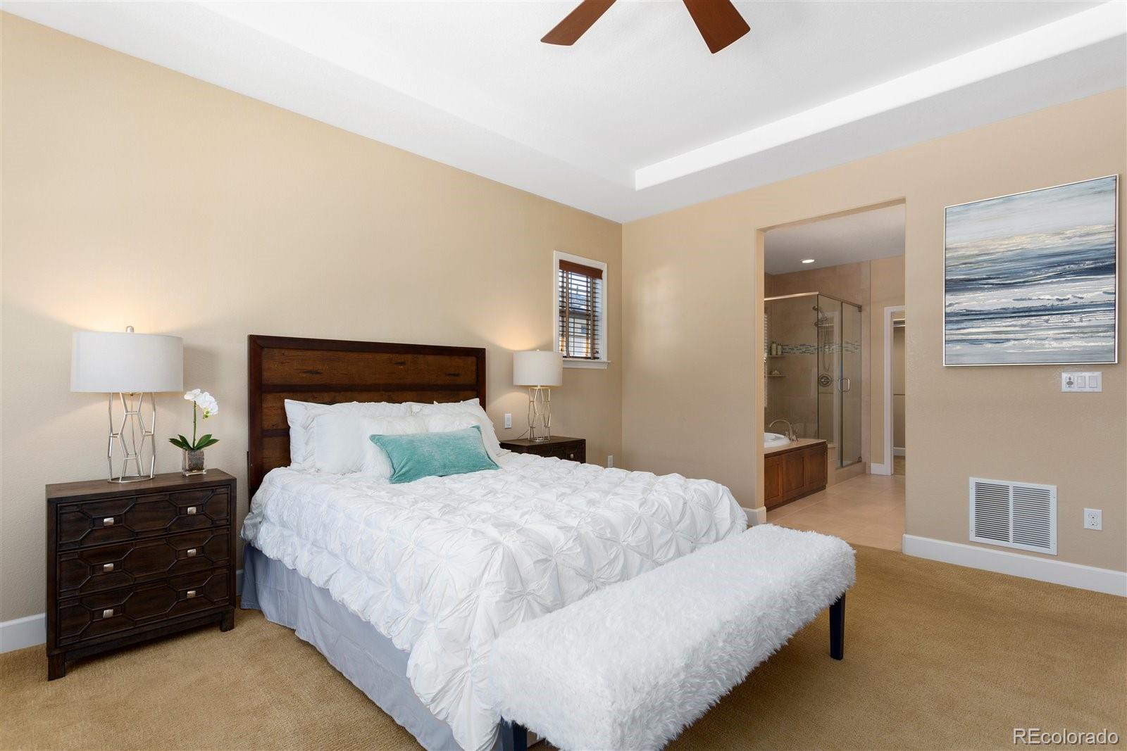 10634 Sundial Rim Road Highlands Ranch, CO 80126 - Photo 26 of 40 a bedroom with a bed and a lamp on table