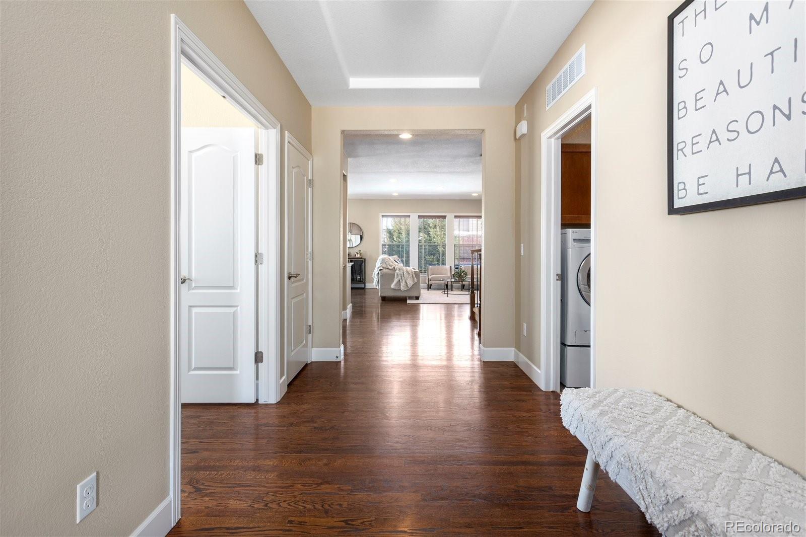 10634 Sundial Rim Road Highlands Ranch, CO 80126 - Photo 7 of 40 a view of a hallway with wooden floor and a bathroom