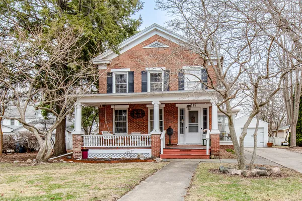 a front view of a house with a tree