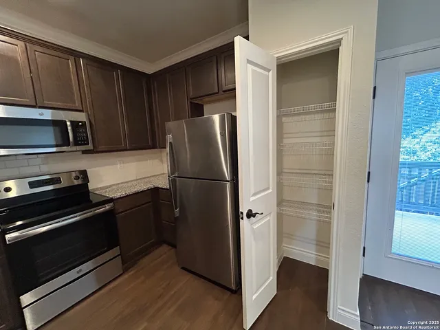 a kitchen with a refrigerator cabinet and a microwave