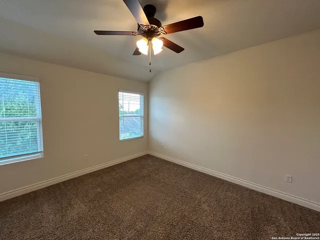 an empty room with a window and a fan