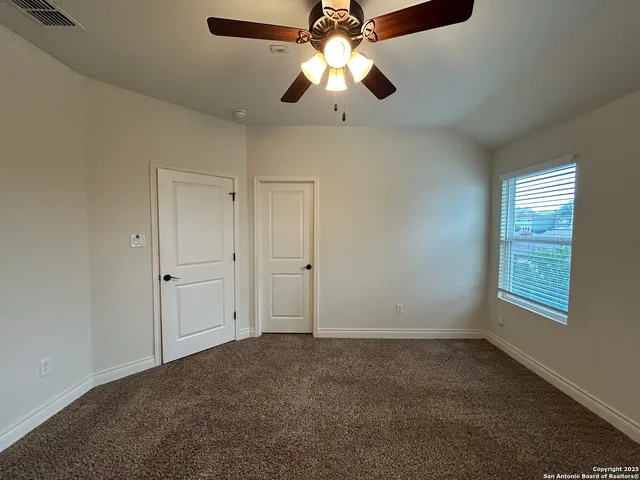 an empty room with windows and fan