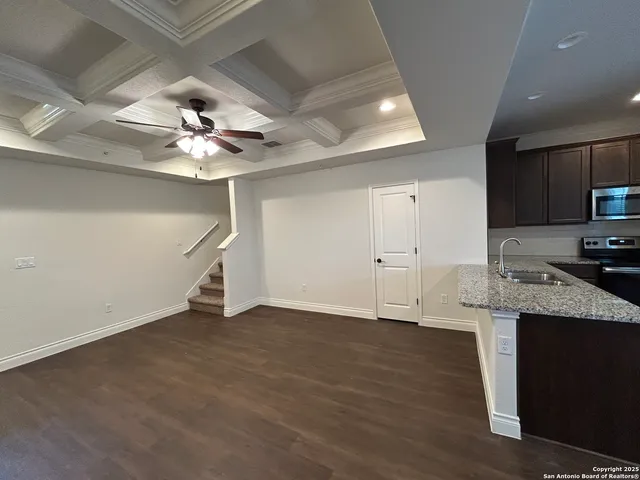an empty room with wooden floor and ceiling fan