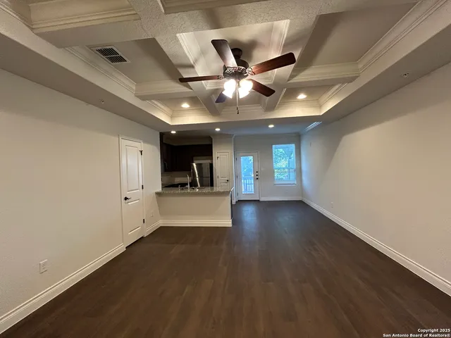a view of empty room with wooden floor