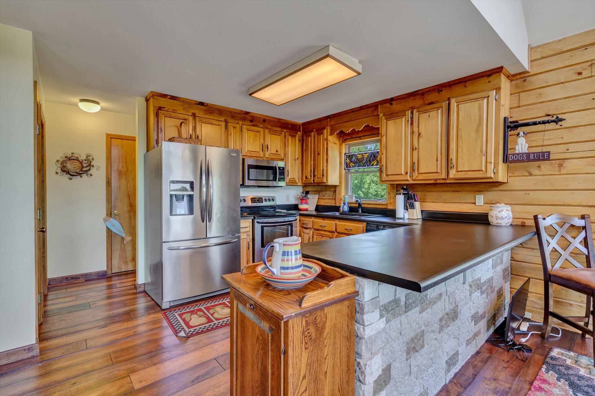 3499 Kemp Ford Road Union Hall, VA 24176 - Photo 10 of 52 a kitchen with granite countertop a refrigerator a sink dishwasher a stove and a dining table with wooden floor