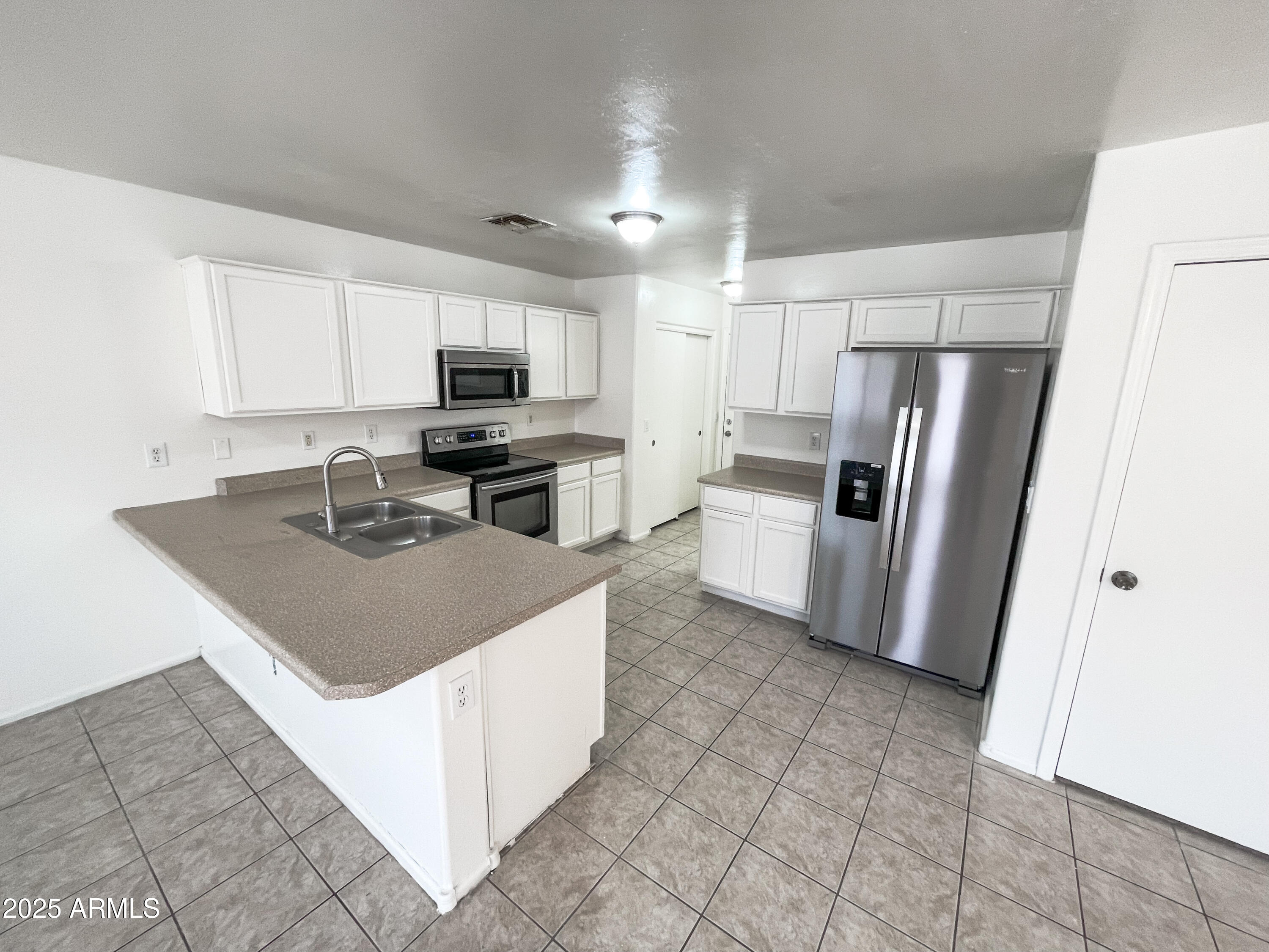 41389 Hopper Drive Maricopa, AZ 85138 - Photo 2 of 17 a kitchen with stainless steel appliances granite countertop a refrigerator stove microwave and sink
