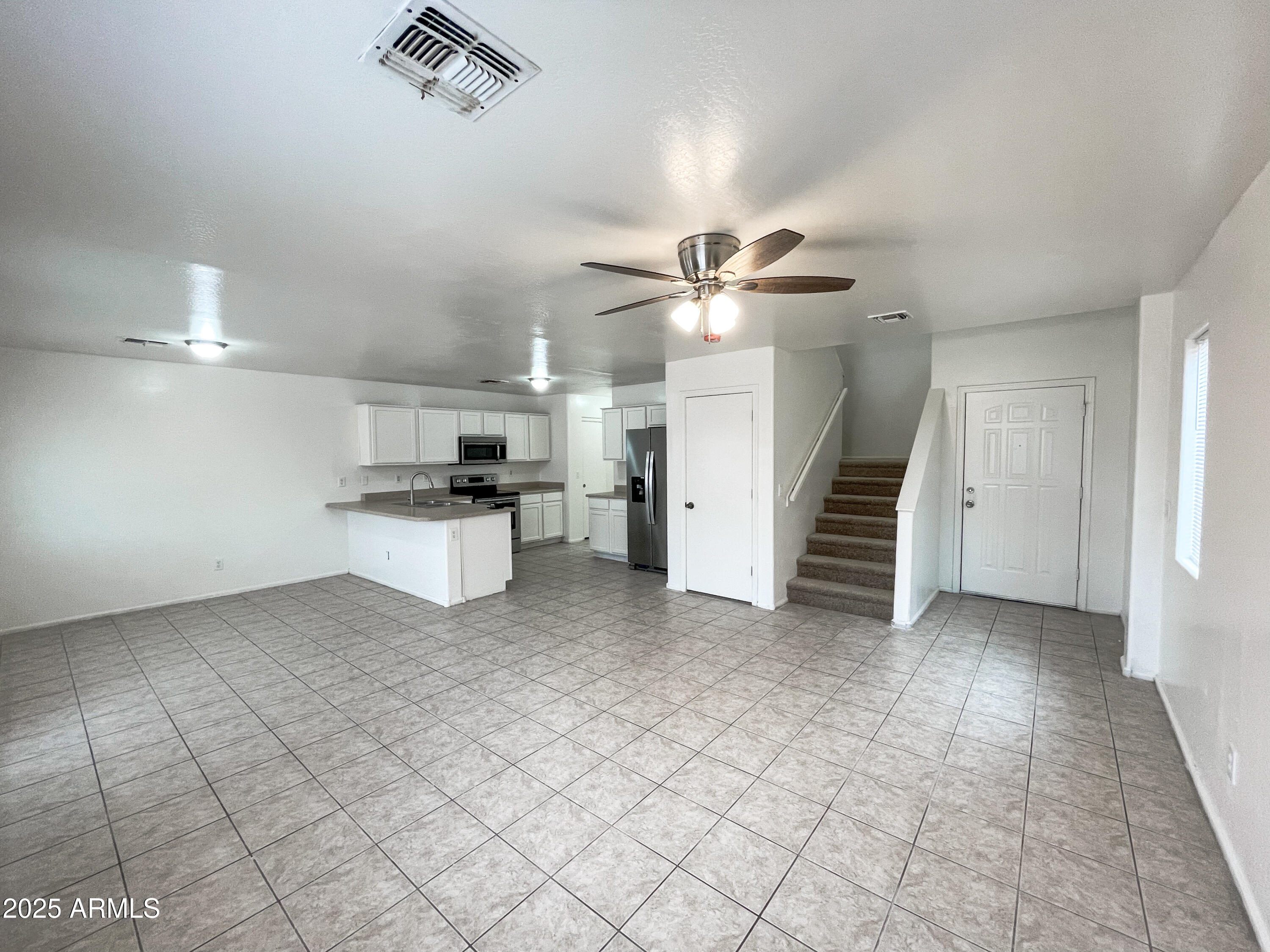 41389 Hopper Drive Maricopa, AZ 85138 - Photo 3 of 17 an empty room with white walls and ceiling fan