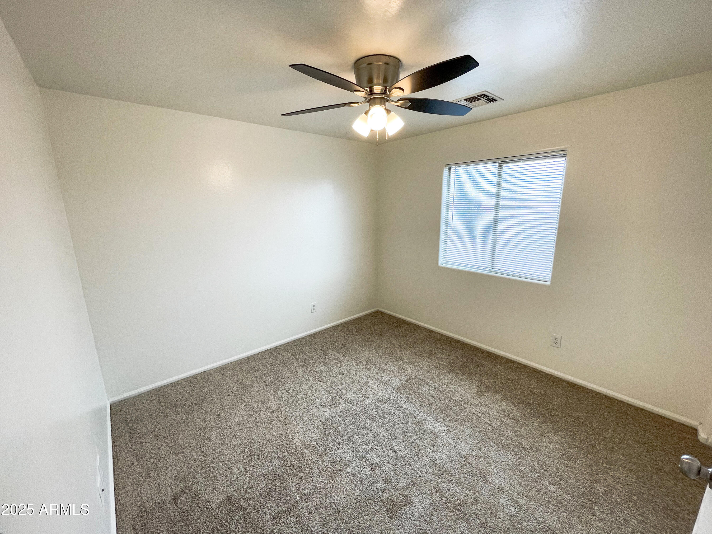 41389 Hopper Drive Maricopa, AZ 85138 - Photo 8 of 17 an empty room with windows and fan
