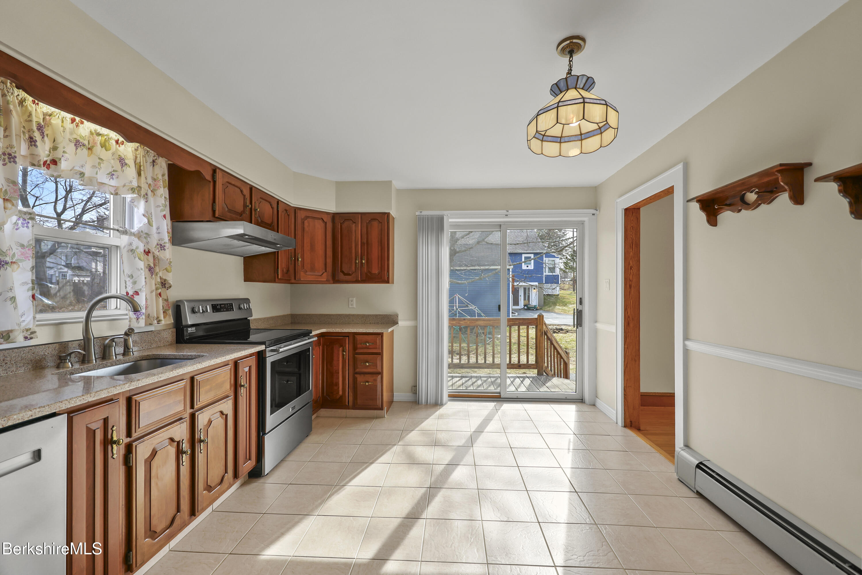 12 Sherrill Avenue Pittsfield, MA 01201 - Photo 11 of 40 a kitchen with stainless steel appliances granite countertop a stove top oven a refrigerator a sink and dishwasher with a dining table