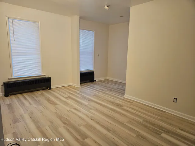 a view of empty room with wooden floor