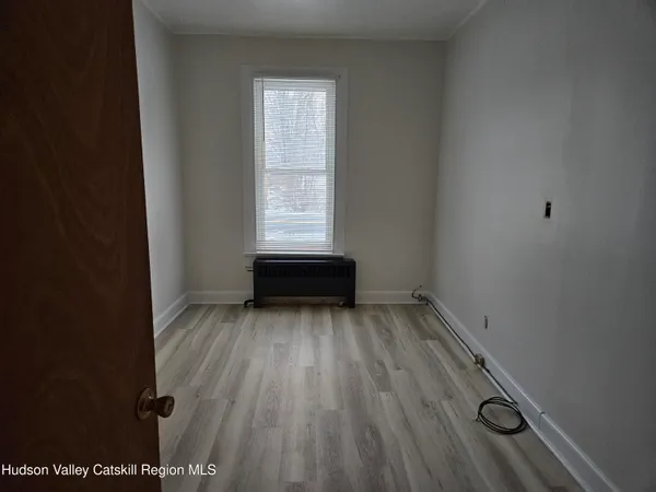 a view of a room with wooden floor and window