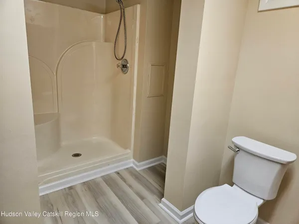 a white toilet next to a bathroom