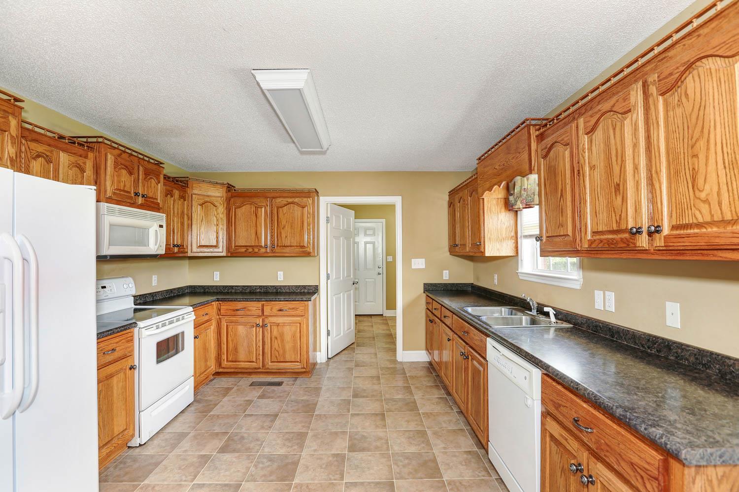 25156 Sand Springs Road Athens, AL 35613 - Photo 7 of 24 Kitchen - With lots of cabinetry and counter top space plus all four appliances to convey. Door at the far end leads to the spacious laundry room.