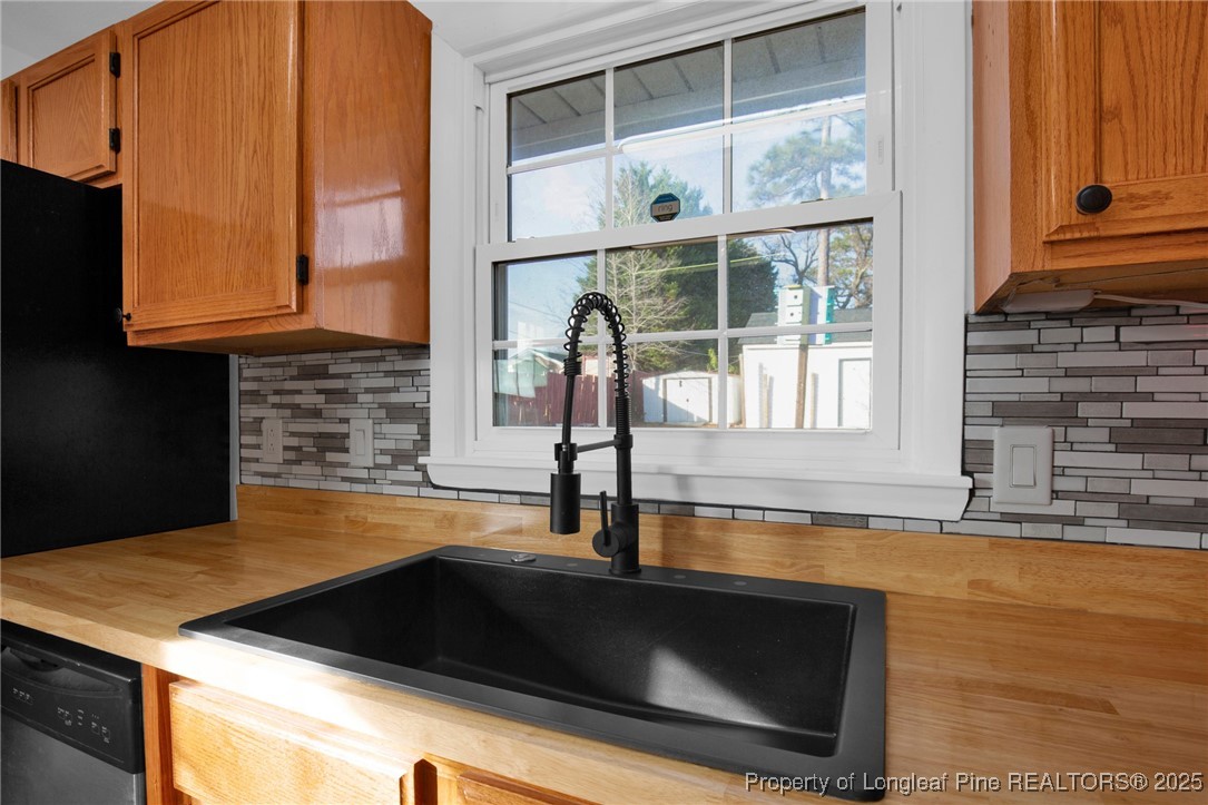 6806 Beaver Stone Road Fayetteville, NC 28314 - Photo 16 of 42 a kitchen with granite countertop a stove and a sink