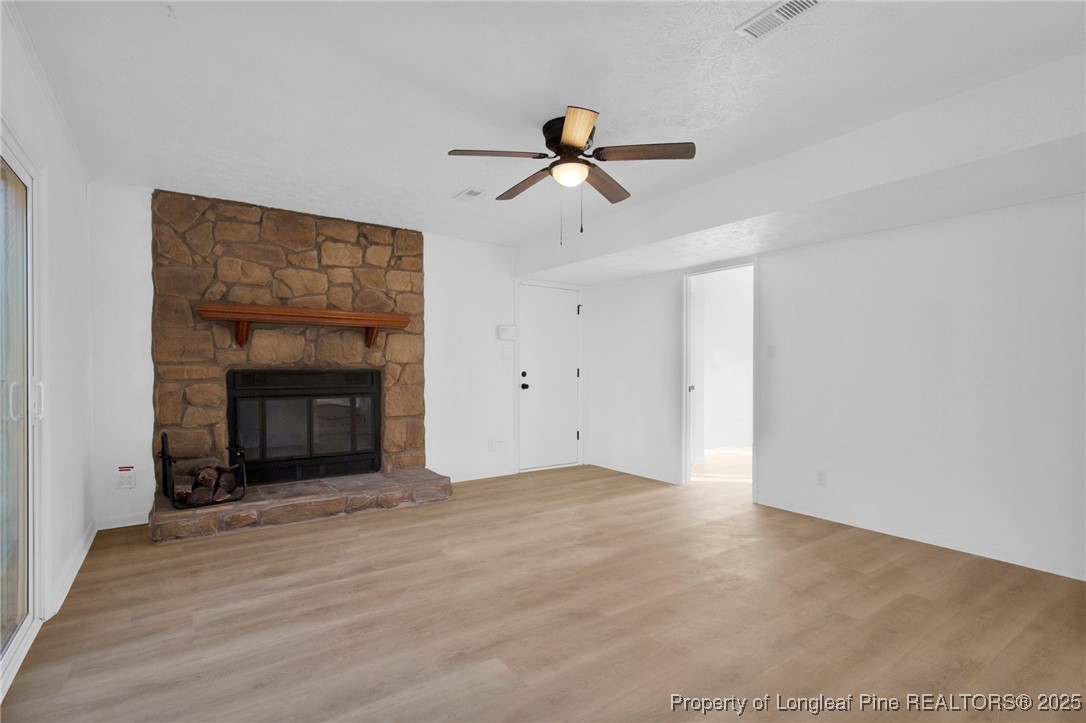 6806 Beaver Stone Road Fayetteville, NC 28314 - Photo 19 of 42 a view of empty room with wooden floor and a fireplace